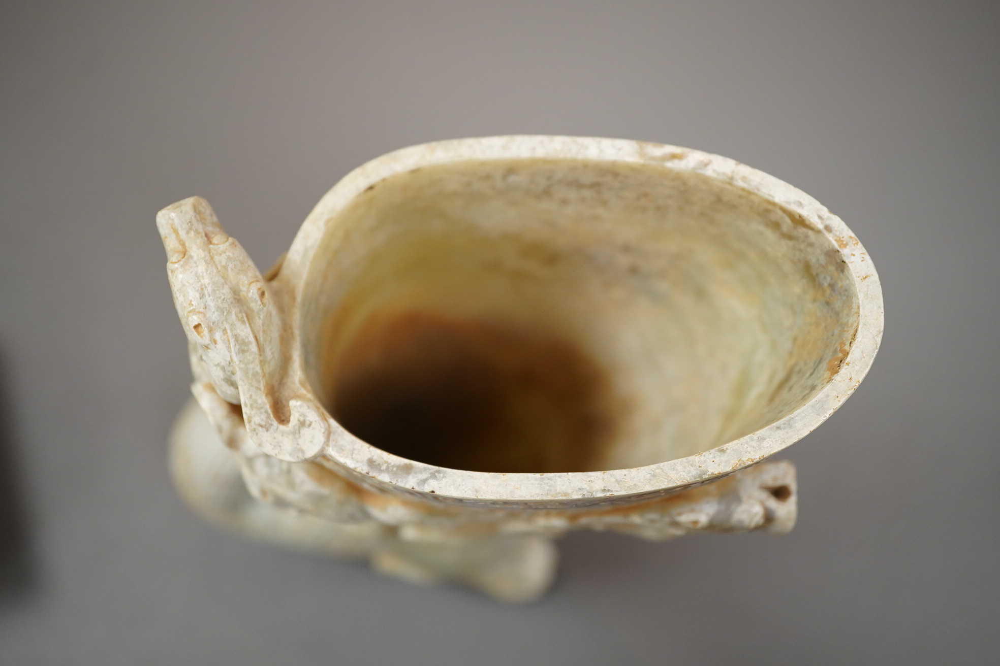 A large Chinese archaistic pale celadon and calcified jade rhyton